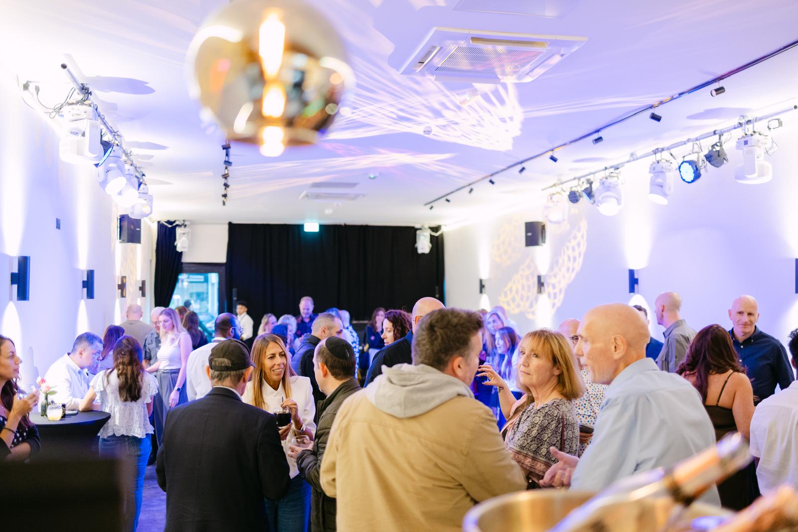 Guests gathered inside No15 Event Space beneath layered event lighting