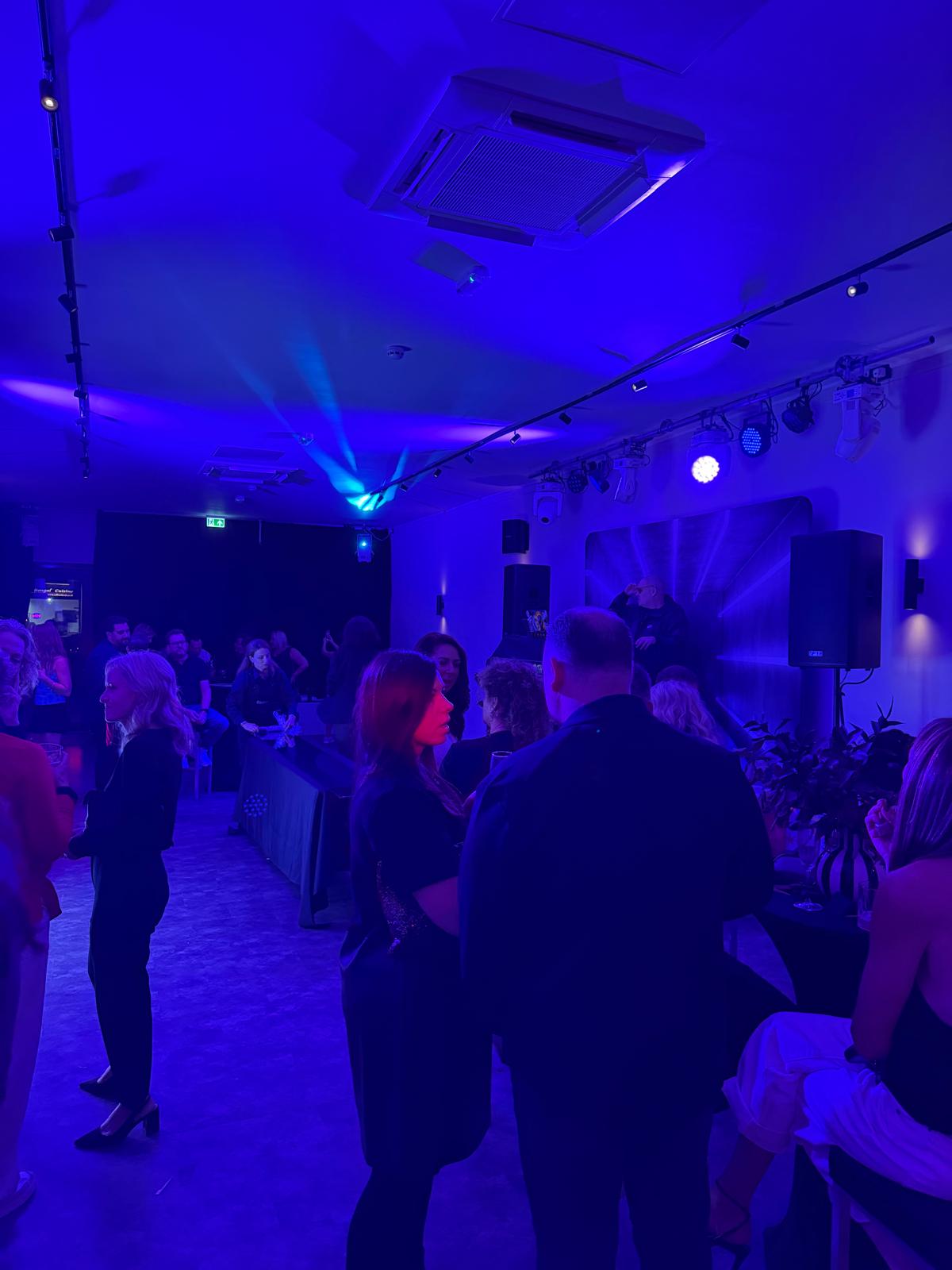 Blue-lit gathering in the venue